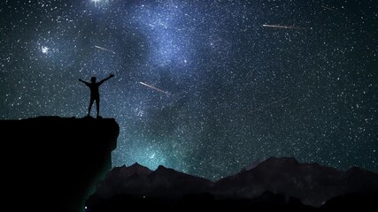 Wall Mural - man on a mountain top watching the starry night sky with shooting stars.
