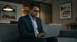 © DianneF - Professional Man in Dark Blue Suit Working on Laptop Indoors