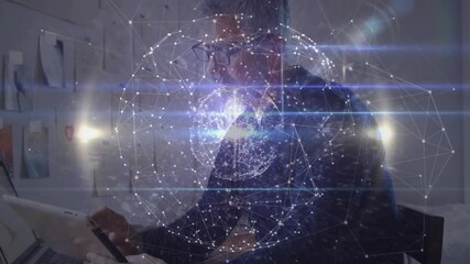 Poster - Male designer leaning at desk, using laptop, tapping tablet, enlarging network globe for analysis
