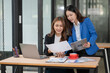 © Thitisak - Two young female businesswomen are meeting in an office.