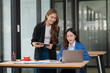 © Thitisak - Two young female businesswomen are meeting in an office.