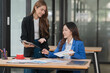 © Thitisak - Two young female businesswomen are meeting in an office