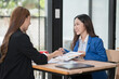 © Thitisak - Two young female businesswomen are meeting in an office