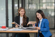 © Thitisak - Two young female businesswomen are meeting in an office