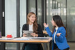© Thitisak - Two young female businesswomen are meeting in an office.