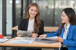 © Thitisak - Two young female businesswomen are meeting in an office.