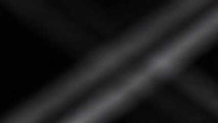 diagonal spotlights shine across a dark background, creating bright cross shape in the center.
