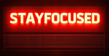 Poster - Bright red neon sign displays STAYFOCUSED. Dark background emphasizes glowing text, grid pattern below message. Simple, motivational design.