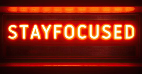Poster - Bright red neon sign displays STAYFOCUSED. Dark background emphasizes glowing text. Simple, motivational message. Modern aesthetic.