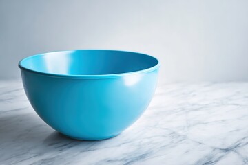 Poster - Bright blue bowl resting on a marble surface, creating a vibrant contrast in a modern kitchen setting during daylight