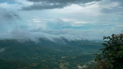 Wall Mural - Timelapse of dreamy cloudscape over green valley in a majestic natural scene