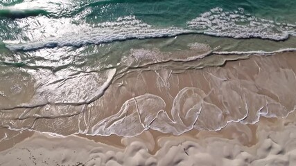 Poster - Pristine beach harmony with gentle waves, turquoise water, and smooth sand create peaceful coastal scene with aerial beach sand