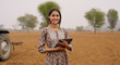 © Raushan_films - Indian young adult village woman wear casual dress tablet tab gadget do online work look camera farmer field teen age girl lady use device screen posing staring cam outside desi life