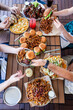 © Stacy Howell - Table with wings, burgers, fries and hummus with people eating
