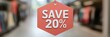 © Tanakrit - Red sale tag offering 20% discount hanging in a retail store aisle, promoting savings and special offers to shoppers.
