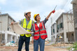 © Supachai - Civil male engineer holding blueprints and Asian female architect with walkie talkie working together inspection housing estate project at the construction site