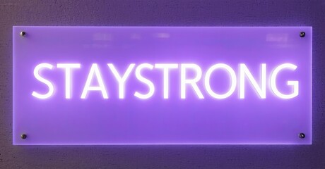 Poster - Bright purple neon sign displays STAYSTRONG. Wall background is dark, textured. Simple, motivational message presented visually.