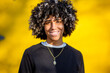 © Paula - Smiling teenager with skin condition and curly hair against yellow background