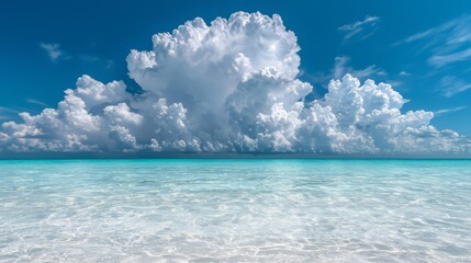 Poster - Large cloud is in the sky above a calm blue ocean. The sky is mostly clear, with only a few clouds scattered throughout. Scene is peaceful and serene, with the vast expanse of water