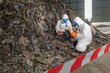 © BESTIMAGE - Environmental Cleanup Team in Full Protective Gear Removing Hazardous Waste from Landfill Site for Environmental Safety and Pollution Control