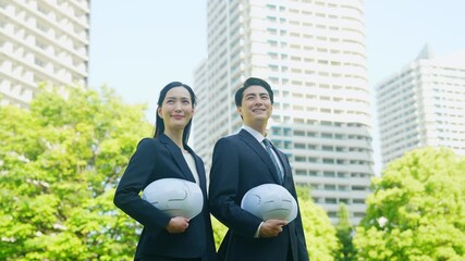 Aufkleber - 新緑の街の前にヘルメットを持って立つビジネスパーソンのグループ