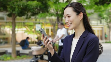 Aufkleber - 新緑の街でスマホを使う女性ビジネスパーソン