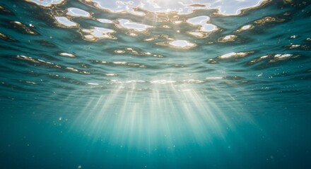 Wall Mural - ocean surface from below, with ripples and sunbeams visible above