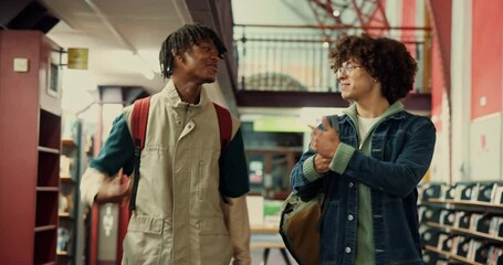 Poster - Greeting, men and students in library at university with conversation, bonding or handshake. Happy, talking and male friends walking on campus for discussion on college scholarship at academy.