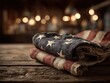 © Dreamer Studio - Patriotic scene featuring a folded American flag on a wood-textured tabletop bathed in warm ambient light, ideal for branding and message space