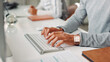 © Claytonon/peopleimages.com - Computer, hands and typing with business person at desk in office for administration or report. Keyboard, planning and research with employee at work for online development, feedback or review