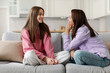 © Home-stock - Mother listening to teenage daughter with empathy and understanding while sitting together on sofa, teen girl sharing secrets with mom