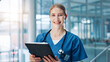 © peopleimages.com - Nurse, woman and happy with tablet in portrait, lobby and report for healthcare services at clinic. Person, technology and smile with application, medical research and results at hospital in Germany