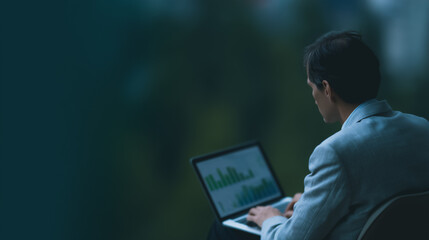 Poster - Late Night Data Analysis: A businessman sits outdoors at night, reviewing data on his laptop.  The focus is on his concentration, illuminated by the screen's glow against a dark background.