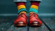 ©  zikakant - A vibrant display of red shoes paired with bright, colorful socks, standing on a rustic floor, creating an eye-catching and stylish fashion statement.