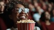 ©  zikakant - A joyful woman with glasses grins widely while holding a striped bucket of popcorn in a movie theater, embodying the excitement and joy of enjoying a film experience.