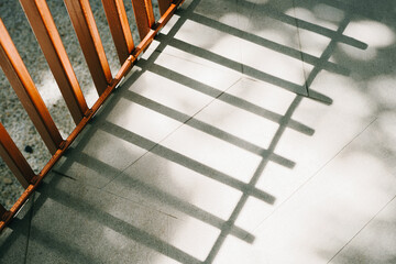 Poster - Shadows of Wooden Fence on Smooth Floor with Play of Light and Texture in a Contemporary Setting