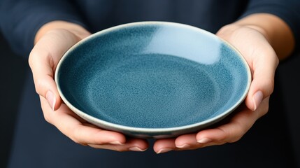 Poster - Gentle hands elegantly hold a beautifully crafted blue ceramic plate, symbolizing artistry and the appreciation of craftsmanship in everyday objects.
