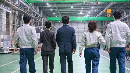 Fototapete - 工場の中を歩く作業スタッフのグループ