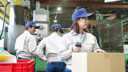 Poster - 工場でハンディターミナルを使って製品を検査する女性作業員