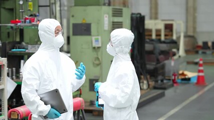 Poster - 工場の中で機械を操作する防護服を着た男女作業員