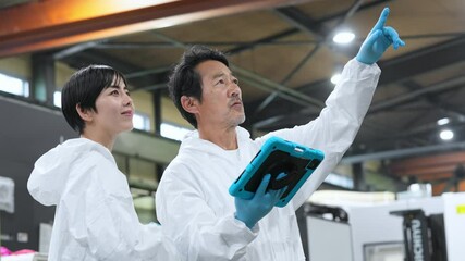 Poster - タブレットPCを持って工場を点検する防護服を着た男女作業員
