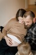 © Ananass - Expecting Parents with Child in Cozy Home Setting