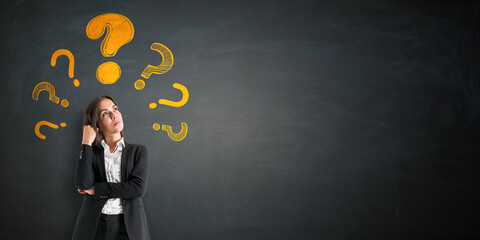 Fototapete - Businesswoman thinking with yellow question marks above head on black wall background, concept of curiosity, problem solving, and education mockup.
