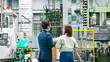 © metamorworks - 工場を視察する男性ビジネスパーソンと女性作業員