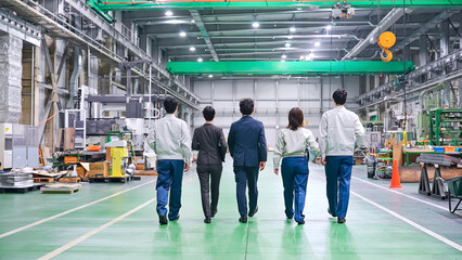 Fototapete - 工場の中を歩く作業スタッフのグループ