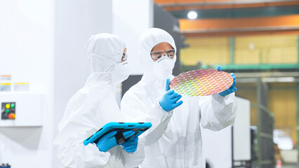 Poster - 半導体工場でタブレットを持ってシリコンウエハーを検査する防護服を着た男女作業員