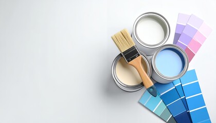 Poster - Overhead view of paint cans with a paintbrush and color swatches on a white surface, showcasing home improvement and design elements. copy space text