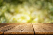 © Надія Коваль - Rustic wooden tabletop with a blurred green forest background, ideal for displaying natural products, outdoor meals, or seasonal content in a warm and organic setting