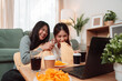 © Kiattisak - Asian Women Snack Food Eating Lifestyle Indoor Living Room Enjoyment Movie, Two Young Adults Sharing Laughter and Snacks While Watching TV, Embracing Friendship and Relaxation at Home Together