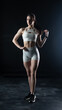 © vadim_fl - Athletic woman standing on black background, showing her fit body